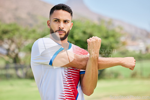 Image of Fitness, sports and soccer player stretching on a football field in training, exercise and workout in Sao Paulo, Brazil. Focus, warm up and serious athlete ready to start a practice match or game