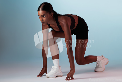 Image of Fitness, runner and commitment of athlete woman ready to start running, race or marathon on blue background for health, wellness and sports training. Female from India for exercise workout motivation