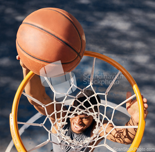 Image of Basketball sports, black man and top view of dunk at basketball court, training game or match. Fitness, energy jump and basketball player scoring point or practice goal, exercise or workout outdoors.