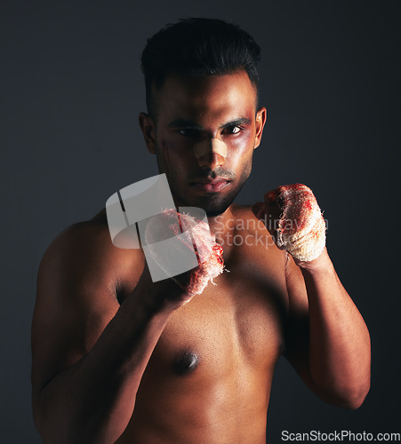 Image of Fight, bruise and bandage with fighter, blood and injury from mma or boxing against a dark studio background. Strong athlete or boxer portrait with wound on hands and eye from fighting or battle