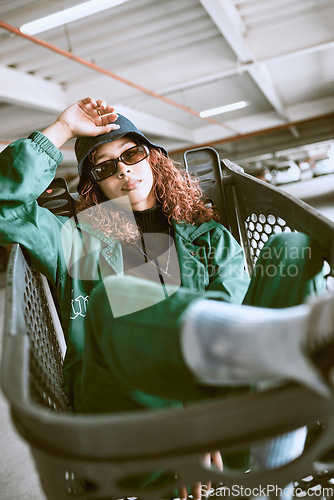 Image of Fashion, clothes and woman in a shopping cart for urban aesthetic in the city of Los Angeles. Supermarket, portrait and fashion model with trendy, stylish and designer sunglasses in road or street