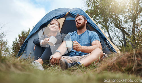 Image of Camping, tent and nature couple with coffee, tea or hot chocolate relax in outdoor forest or woods. Grass field trees, morning view and camper people bond, talk or enjoy quality time peace or freedom