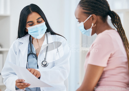 Image of Doctor, covid mask and woman patient medical results in a health consultation in a clinic office. Diversity of women in a hospital, nurse and healthcare appointment with coronavirus consulting check