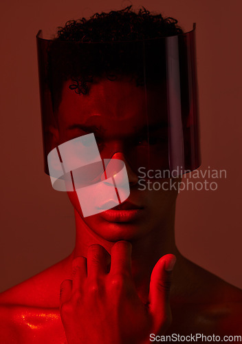 Image of Red future night, black man portrait and futuristic punk glasses on face against dark background in studio. Cyber model man, plastic visor mask and cyberpunk aesthetic with creative wall backdrop