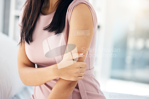 Image of Covid, vaccine and bandaid on arm of woman in hospital for medical, wellness and medicine. Healthcare, virus and flu injection with girl patient and plaster for first aid, sick or treatment in clinic