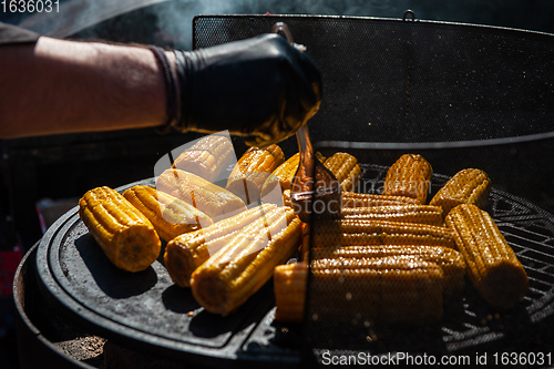 Image of A professional cook prepares corn