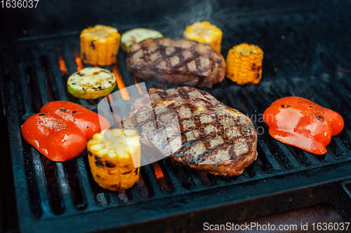 Image of Beef steaks on the grill with flames