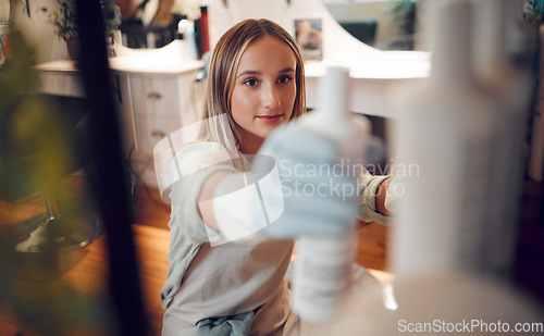 Image of Shelf, woman and gloves in salon with product, spray or shampoo in hair care boutique. Hairdresser, small business owner and female barber from Canada in store or shop looking at cosmetic products.