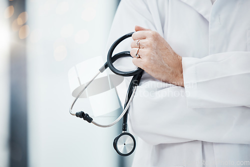 Image of Senior doctor, hands and stethoscope in hospital ready for diagnosis, check up or heart health closeup. Healthcare, expert or cardiologist holding equipment for cardiology exam in doctors office.