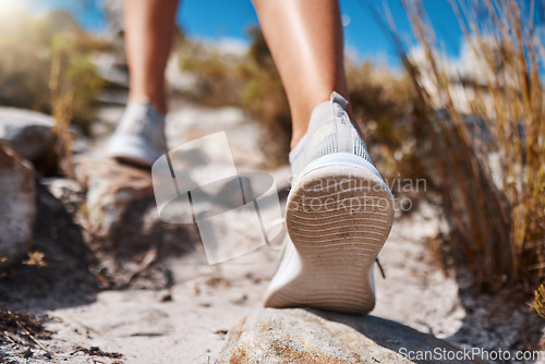 Image of Shoes, hiking and fitness with a woman closeup walking up a mountain trail for exercise, cardio or adventure. Nature, training and feet with a female hiker stepping on a rock while outdoor for a walk