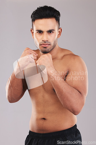 Image of Fist, fight and portrait of an athlete in a studio for sports, MMA or martial arts training. Fitness, defense and strong fighter ready to do a boxing exercise or workout isolated by a gray background