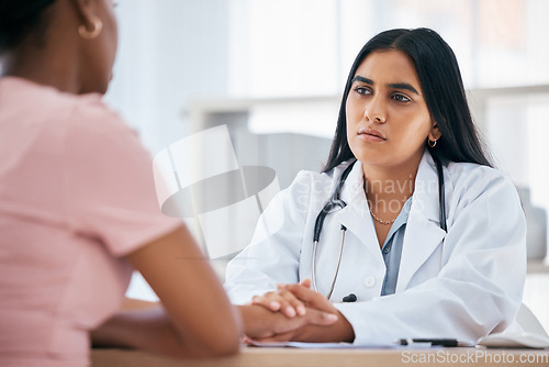 Image of Support, diagnosis and doctor doing a consultation with a patient in medical clinic or hospital. Test results, bad news and healthcare worker consoling and holding hands with black woman in office.