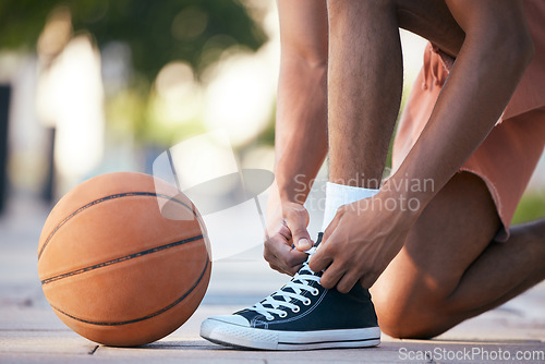 Image of Hands, shoes and basketball in sports motivation for exercise, workout and exercise in the outdoors. Hand of sport player tying lace for ball game, match or training in healthy cardio fitness outside