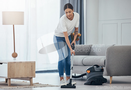 Image of Woman, vacuum machine and cleaning the floor in the living room in home. Happy latino cleaner doing housework, housekeeper or job in a clean lounge, hotel room or house while alone spring cleaning