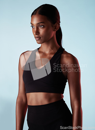 Image of Fitness, health and sports woman in studio for balance, form and motivation. Workout, health and beauty, athlete with goals and vision on blue background, beautiful healthy girl from India in profile