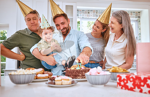 Image of Birthday cake for boy child, home with family and celebrate with food in Texas kitchen. Happy baby smiles in dads arms, candles on dessert and grandparents at first celebration with gifts on table