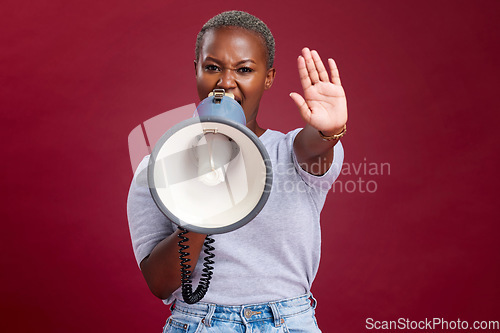 Image of Black woman, protest and shouting with megaphone for voice, strike or stop against a studio background. Portrait of African female activist with hand gesture, vocal or stand for gender based violence