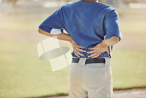 Image of Sports, baseball injury and man with back pain, emergency or muscle strain during game, competition or fitness match. Softball player, field pitch or back view of athlete with hurt spine or backache