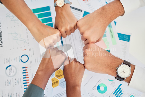 Image of Finance, accounting and team fist bump from above over documents for investing. Teamwork, goal and success of financial experts with hands joined for motivation for partnership, community and report