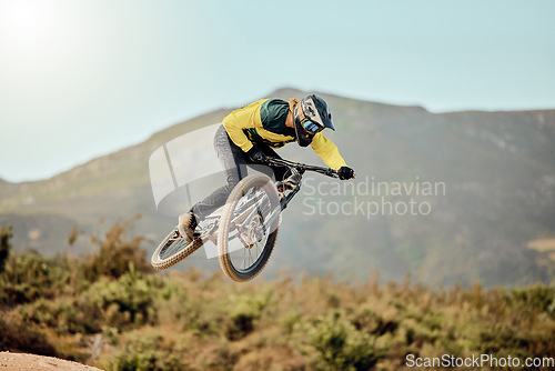 Image of Mountain bike, man and action air jump and bicycle, challenge and adventure, freedom and fast race in nature. Cycling sports athlete, training and energy on mountain for outdoor speed competition