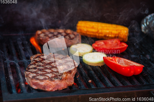 Image of Beef steaks on the grill with flames