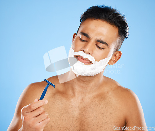 Image of Shaving, grooming and hygiene, man with razor for clean and fresh face, cream and foam product with blue studio background. Facial wellness, healthy skin and skincare, beauty and check blade.