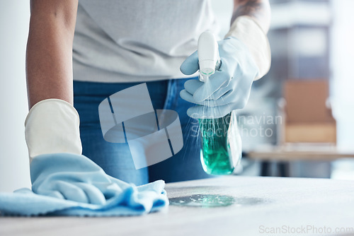 Image of Hands spray, cleaning service and product for dust on table as cleaner on kitchen counter or dirty home furniture. Hand, worker or janitor wash a messy surface with fresh liquid and cloth with gloves