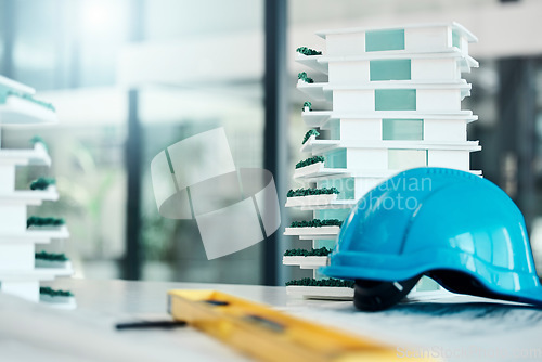 Image of Building model on table, construction design industry and safety helmet for industrial real estate job. 3d plastic apartment architecture project, engineering career and contractor equipment tools