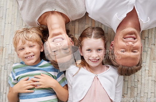 Image of Family, children and portrait of faces with a girl, boy and parents lying on ground or floor of home together from above. Love, happy and smile with a mother, father and kids bonding in the house