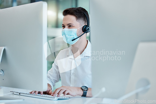 Image of Covid, call center and male consultant offering helpful customer service advice. Crm, telemarketing and contact us consulting at desktop computer with professional operator typing email