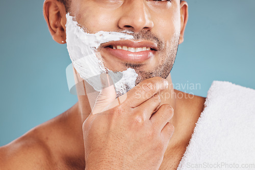 Image of Man with shaving cream on face, beard maintenance and skincare for mens health and beauty treatment with blue background. Health, skin care and facial hair, morning shave bathroom routine with towel.