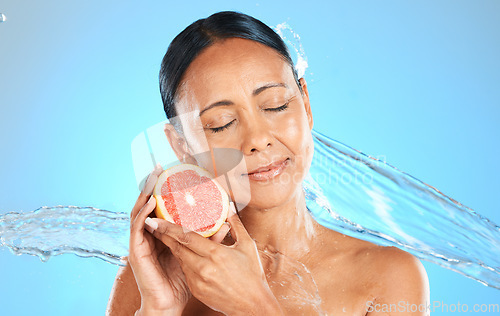 Image of Water splash, fruit and skincare wellness of a woman with a grapefruit feeling health and beauty. Diet, nutrition and healthy skin of a model with natural organic produce feeling calm and peace