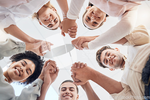 Image of Teamwork, support and collaboration of happy employees with diversity, synergy and trust holding hands and looking down. Men and women team building circle for mental health mission in workplace