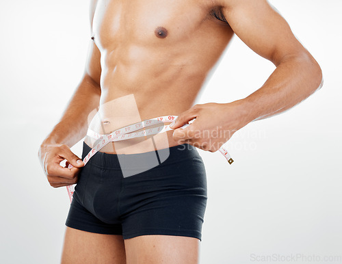 Image of Health, diet and body of man with tape measure to check progress, fitness results and measure stomach waist. Weight loss goals, wellness mindset motivation and underwear model on white background