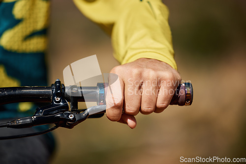 Image of Hand, handle and bike with a man athlete or cyclist riding outdoor for fitness, exercise or cardio. Workout, health grip with a male bicycle rider holding on a handlebar while outdoor for endurance