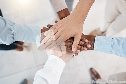 Image of Hands, teamwork and motivation with business people standing in a huddle or circle together from above. Office, meeting and solidarity with a man and woman employee group joined in unity or trust