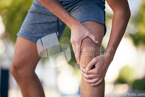 Image of Sports, knee pain and runner man during exercise, cardio and morning run in park. Hand, leg and injury while training for health, fitness and athlete with arthritis in forest against bokeh background