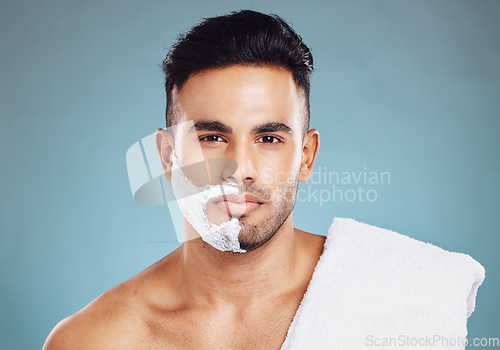 Image of Shaving, beard and man with cream on his face for skincare against a blue mockup studio background. Wellness, health and portrait of a model with soap or foam to remove facial hair with mock up space