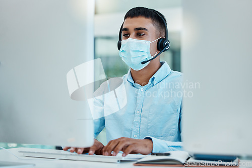 Image of Covid, call center and man typing on computer in office for .database info. Contact us, covid 19 compliance and sales agent in mask offering customer support, service or help and telemarketing online