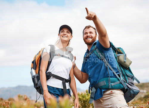 Image of Hiking, happy and couple in nature, relax and smile, hand and pointing while talking and looking around. Friends, hikers and woman with man in forest, exercise, cardio and adventure outdoor together