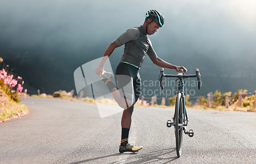 Image of Black man, road and bicycle stretching, fitness or marathon training exercise, triathlon sports and outdoor cycling workout. Mountain bike athlete warm up body, cardio performance and balance focus
