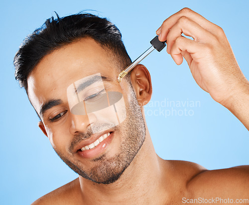 Image of Beard oil, skincare serum and young man face makeup, hair growth product and wellness on blue background. Happy arab guy model drop essential oil, hyaluronic acid and body cosmetics for dermatology