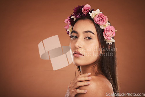 Image of Makeup, beauty and woman with floral crown on head to model for cosmetics, beauty products and fashion. Creative, hair and artistic portrait of girl with flower headband on brown background studio