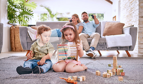 Image of Development, family and children with math toys and playing with building blocks in the house living room. Education, mother and relaxed father watching tv with kids or siblings learning from a game