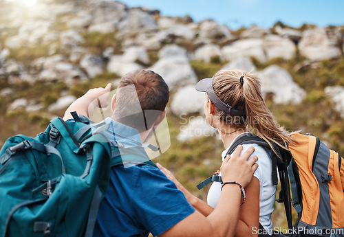 Image of Hiking, couple and mountain in nature with rock, climbing and challenge for fitness, exercise and performance. Hand, man and woman looking up hill, hikers, morning and cardio workout adventure