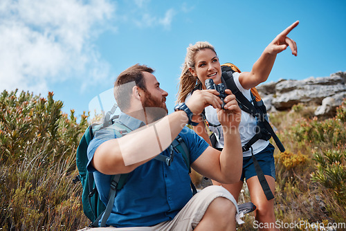 Image of Hiking, couple and in nature to relax, talking and enjoy the outdoor view for fresh air. Health, man and woman point have speaking with tourist, mountain range or vacation with binocular and wellness