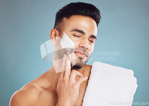 Image of Face, skincare cream and man facial morning routine for beauty care. Young Indian person, hydrate skin treatment and grooming wellness or healthy dermatology bodycare in blue background studio