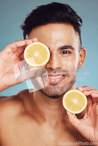 Image of Lemon, vitamin c and natural beauty skincare cosmetics for facial, body care and man happy with results on studio background. Smile model portrait, organic fruit dermatology, healthy and clean face