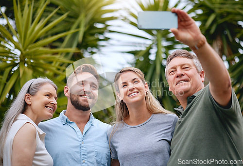 Image of Phone, family and selfie with a man, woman and inlaws posing for a picture together in a garden or yard outdoor. Mobile, happy and smile with a senior father, mother and relatives taking a photograph