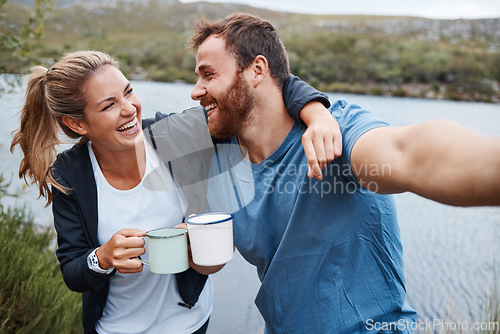 Image of Selfie, coffee and couple by lake on vacation outdoors in nature, holiday or trip. Tea, relax and happy man and woman in love hug by river taking picture for happy memory or social media post online.